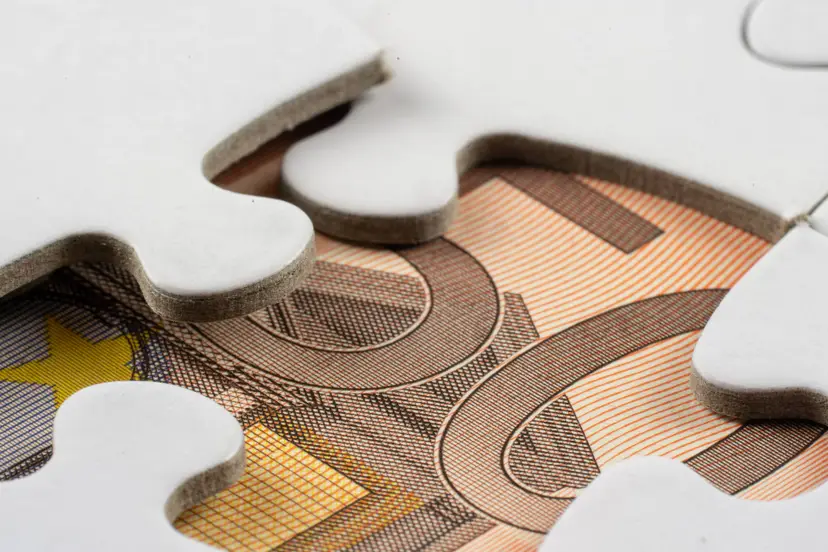 closeup-shot-part-money-seen-removed-piece-jigsaw-puzzle