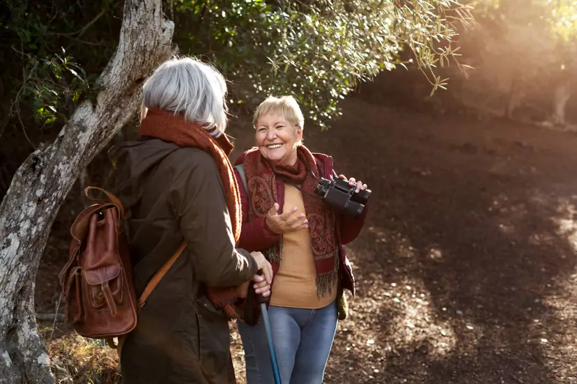 two-senior-female-friends-enjoying-hike-nature-while-using-binoculars