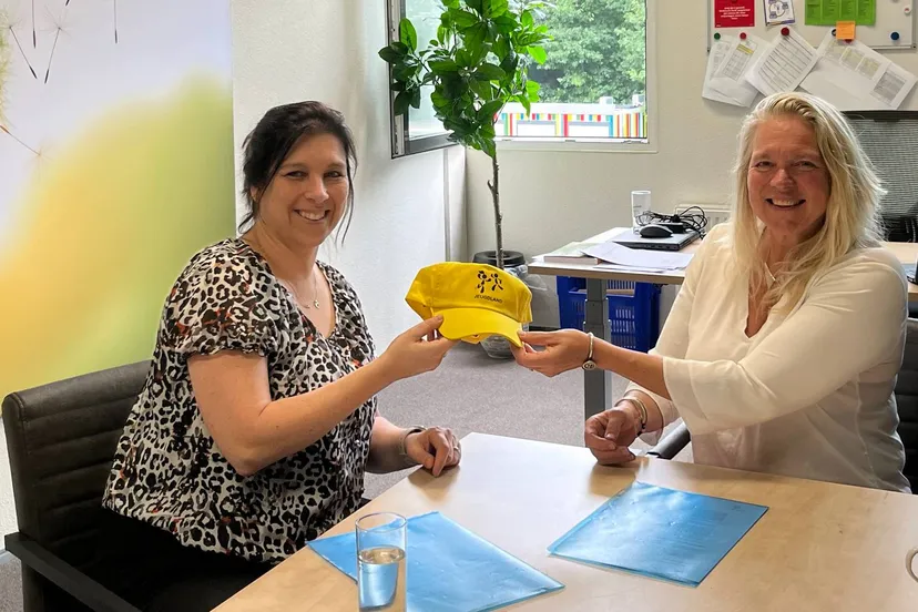 mirjam geers links overhandigt carin veringa rechts een petje van jeugdland