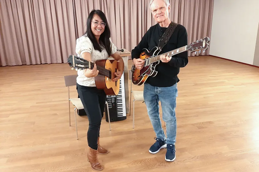 Lenna en Wim staand met gitaren kijken naar de camera