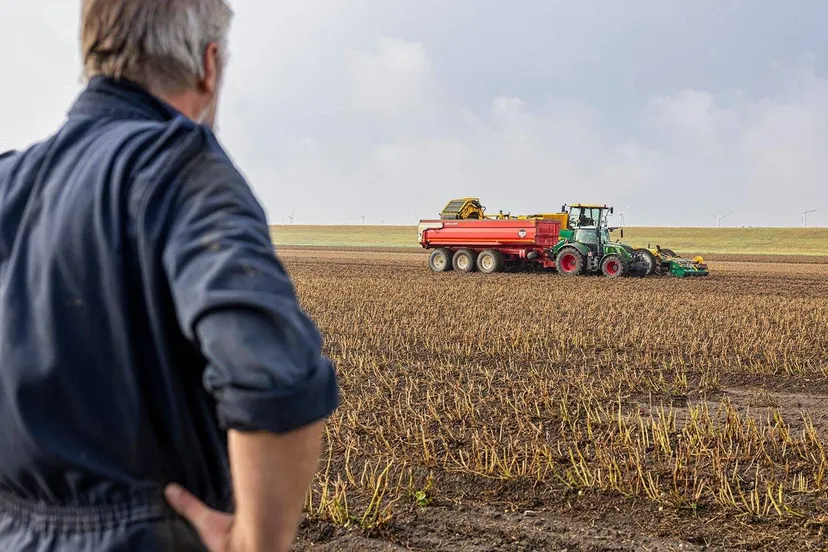 boer kijkt naar landbouwmachine prov flevoland