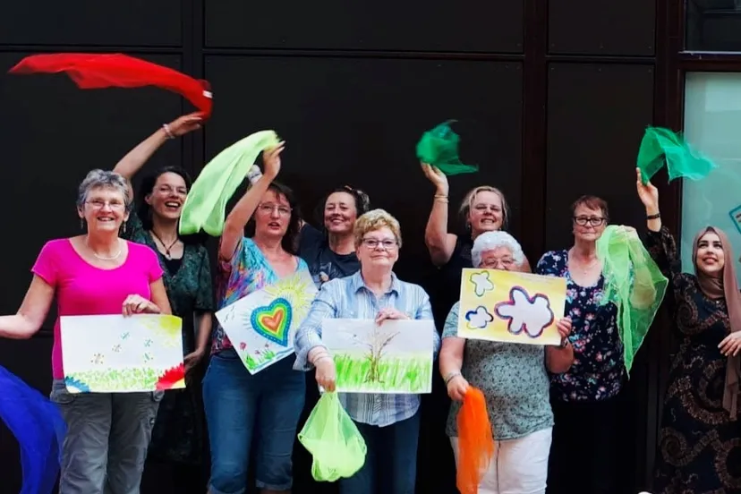 deelnemers van de zomerworkshop zingen en schilderen poseren trots met hun schilderijen foto stichting piezo