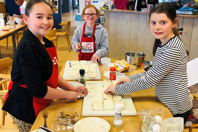 kinderen in buytenwegh zijn druk bezig met het voorbereiding van hun slotdiner fotograaf stichting piezo