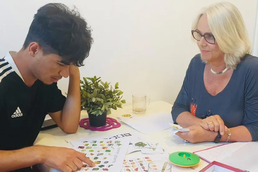 taalcoach marcia en deelnemer nesar zijn bezig met taaloefeningen en taalspelletjes om zo de woordenschat van nesar te vergroten foto 1 fotograaf stichting piezo