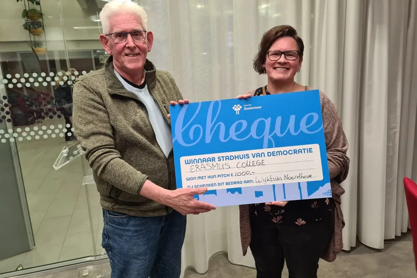 vrijwilliger rob en sociaal cultureel werker odettte nemen de cheque in ontvangst foto stichting piezo