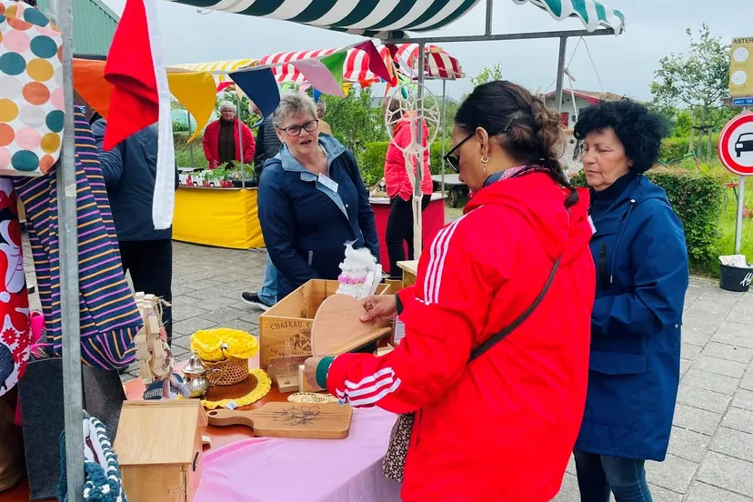 vrijwilligers van piezo verkopen spullen van de upcyclestore tijdens het jubileumfeest van tuinvereniging seghwaert foto stichting piezo