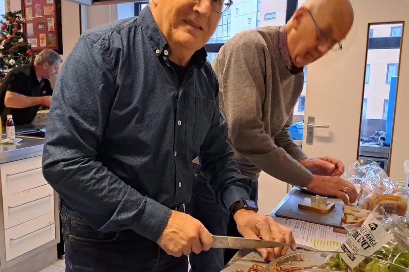 deelnemers van de kooklessen voor mannen koken samen een heerlijk kerstdiner foto stichting piezo