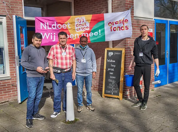 inburgeraars steken de handen uit de mouwen tijdens nldoet fotograaf leon koppenol