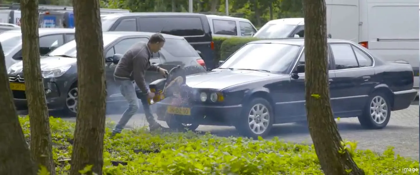 man zaagt auto in twee