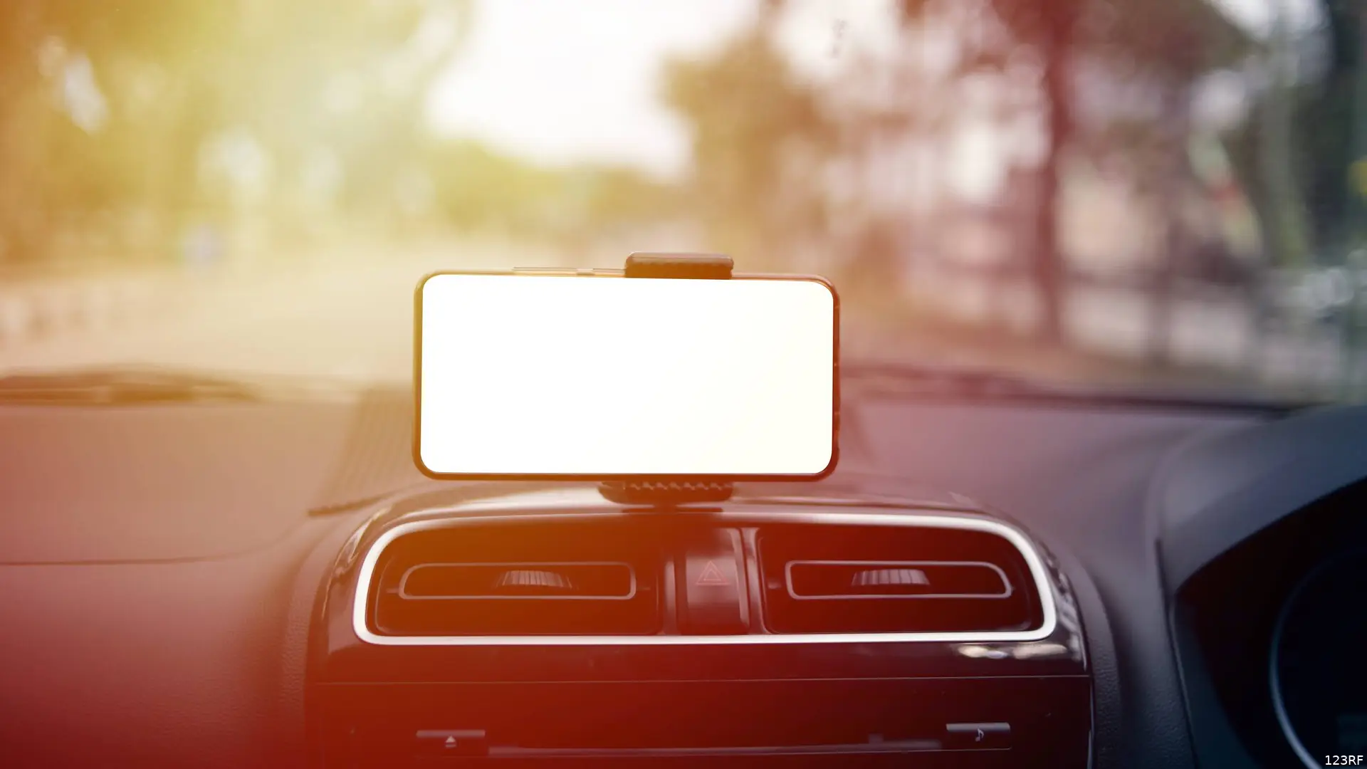Een smartphone in een houder achter de voorruit filmt de weg tijdens een autorit.