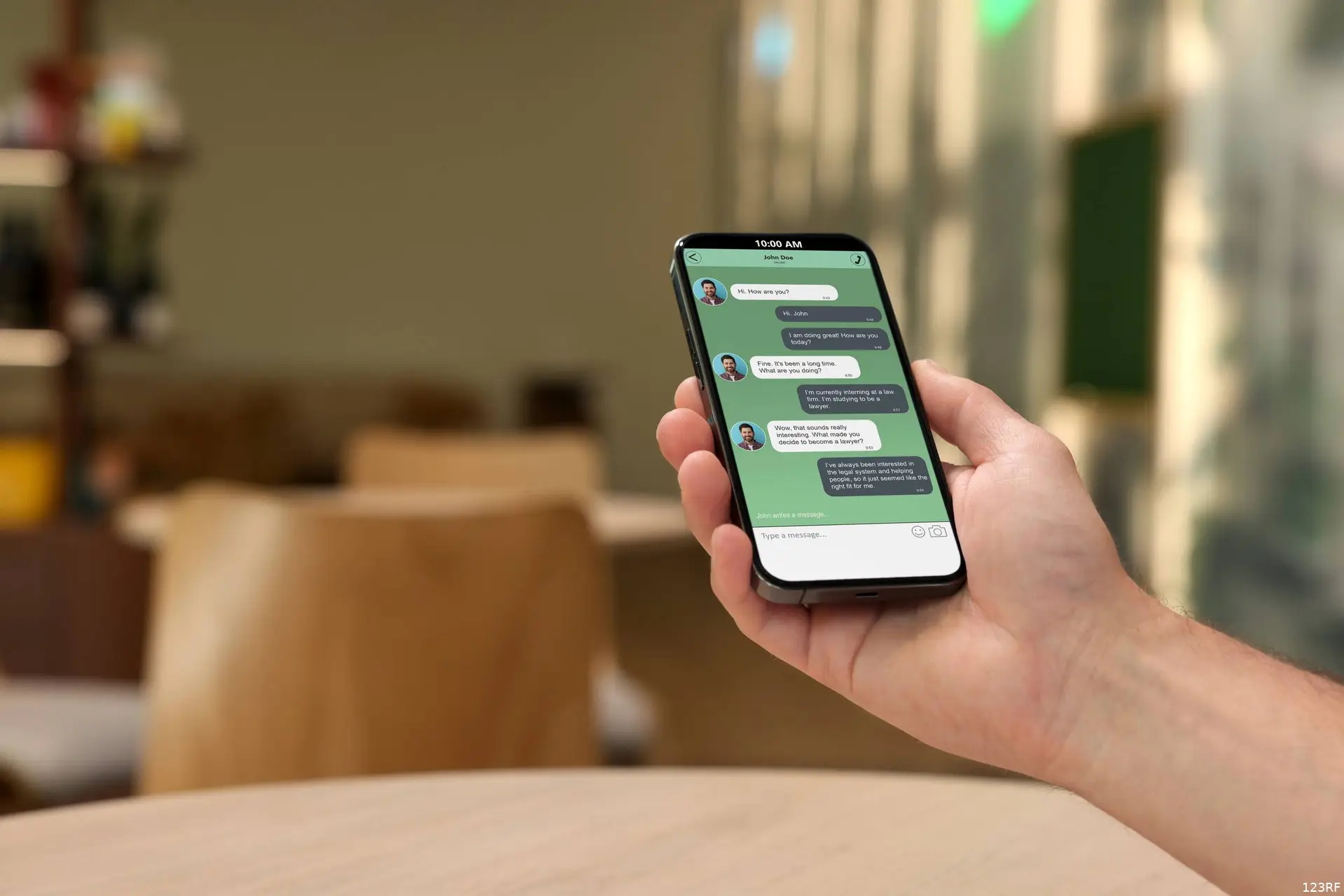 Een hand houdt een smartphone vast met een WhatsApp-gesprek op het scherm.