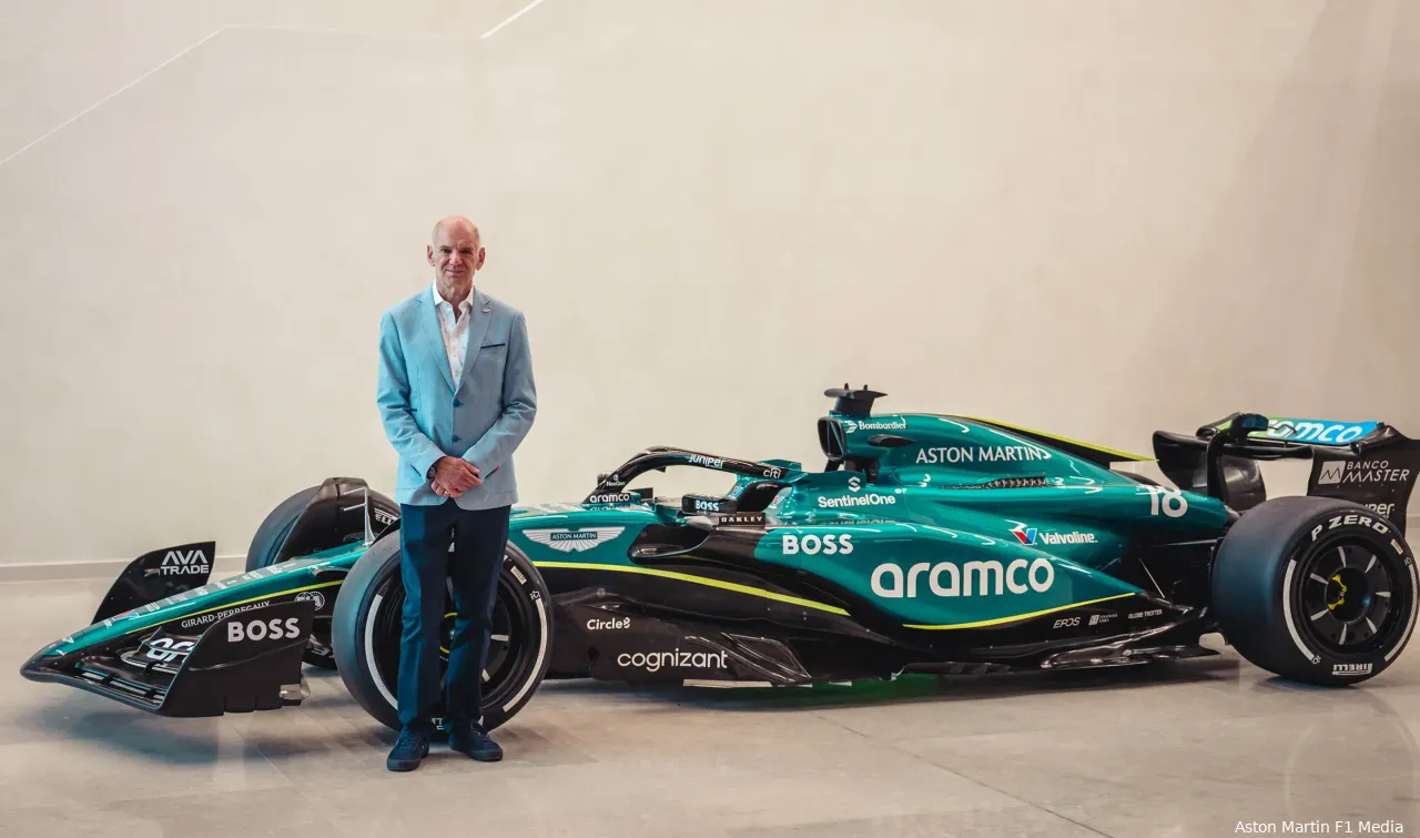 Adrian Newey posing for a picture next to a copy of Aston Martin's 2024 F1 car in a factory at Silverstone on the day of the announcement.