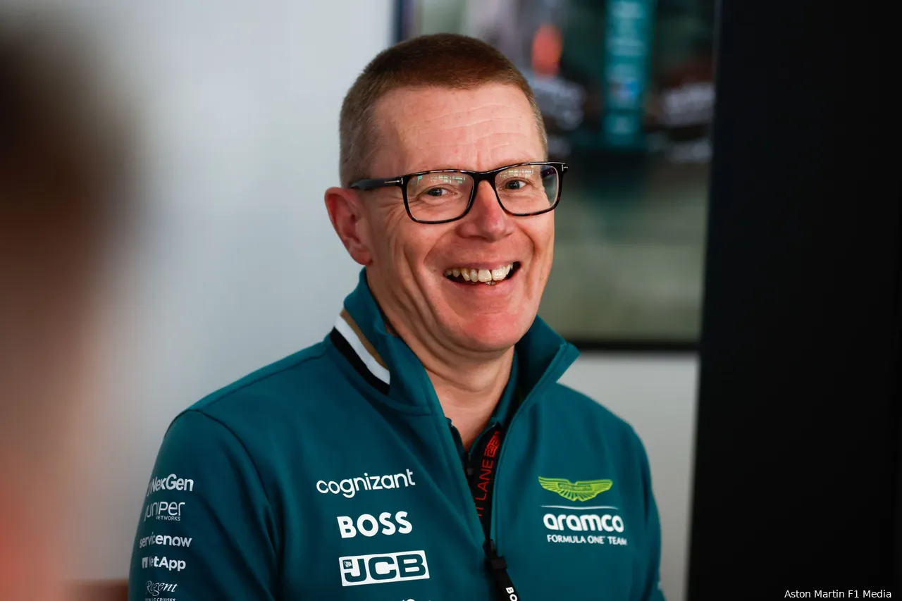 Aston Martin F1 team principal and CEO Andy Cowell smiling at the camera with a blurred background behind.