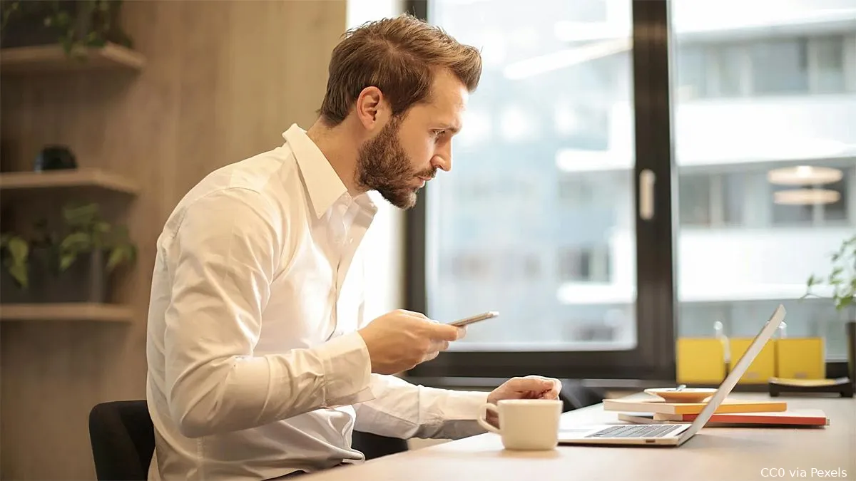 man kop koffie laptop mobiele telefoon