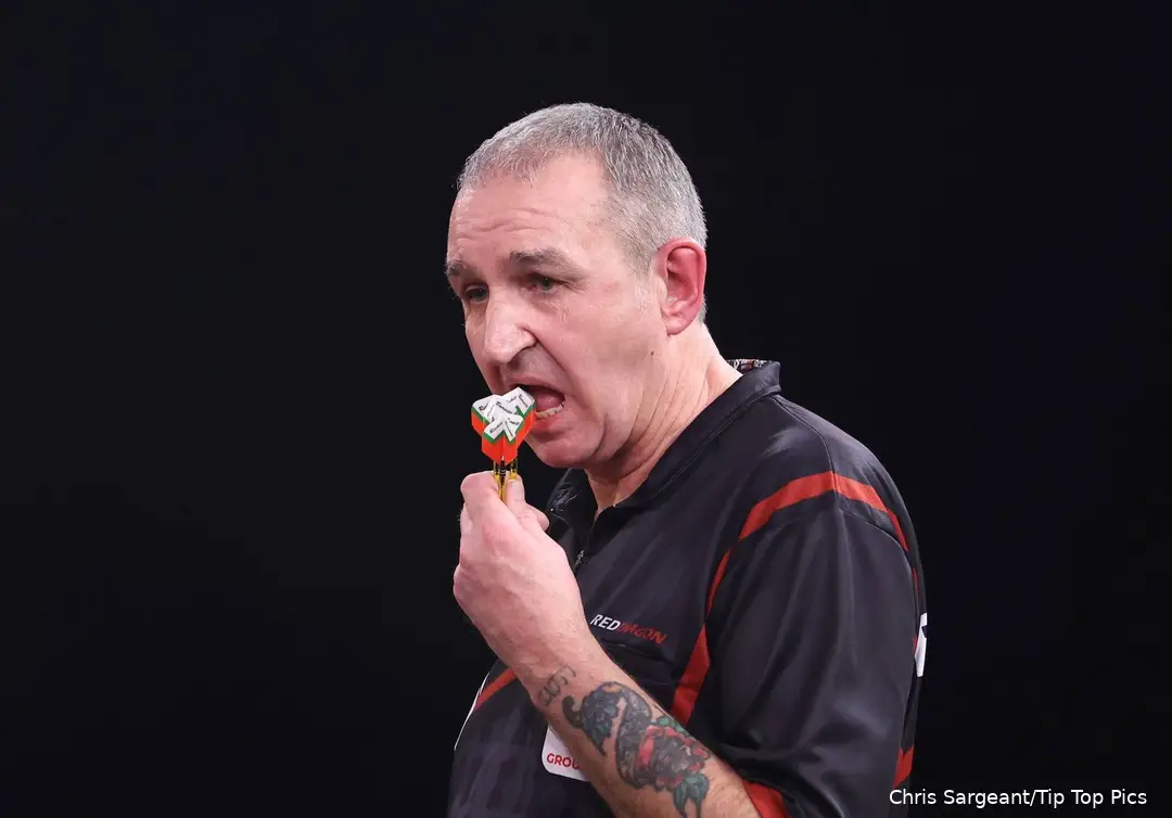 Richie Burnett chewing on his darts