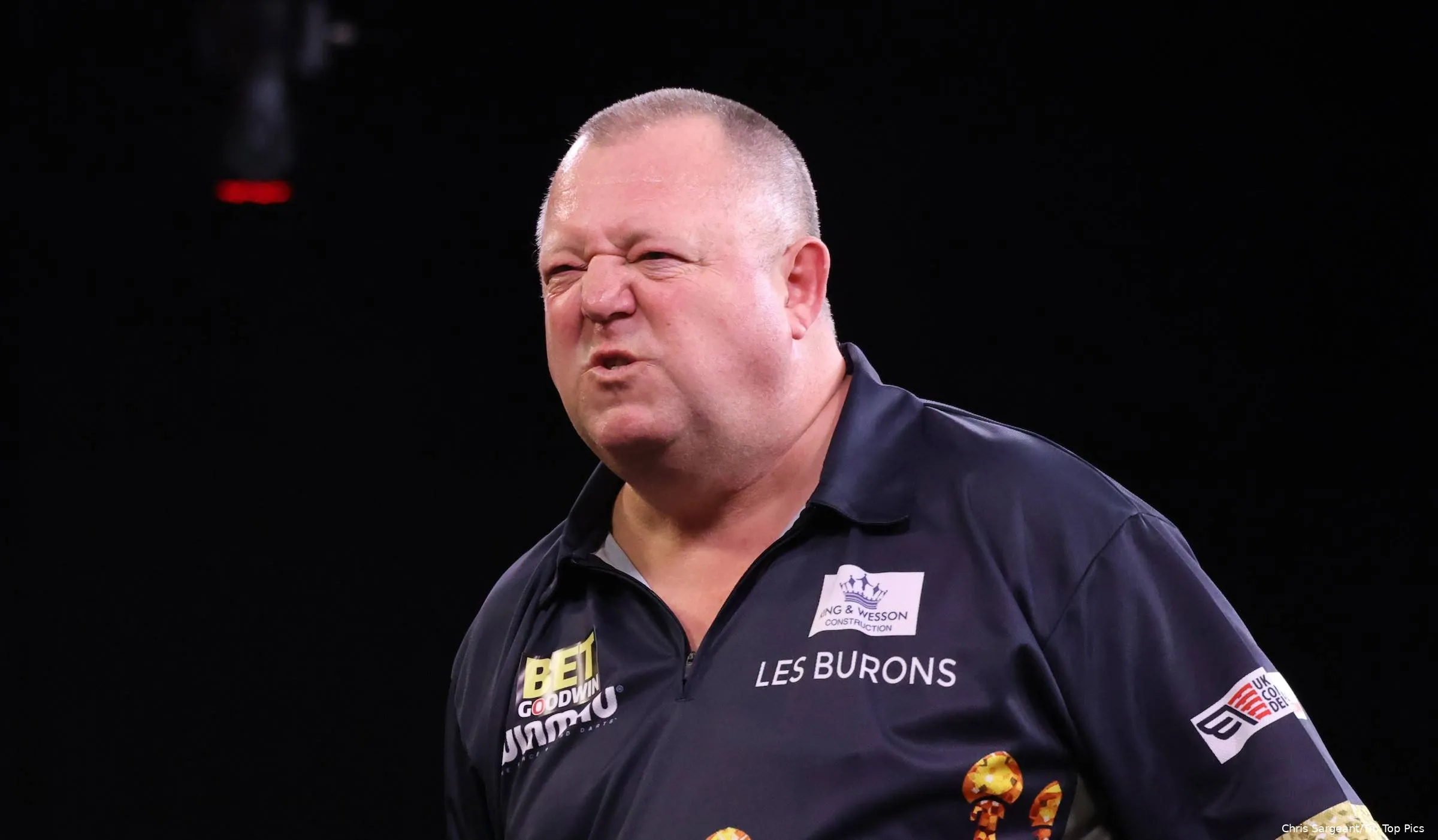 Mervyn King gromt op het podium.