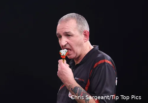 Richie Burnett kaut auf seinen Pfeilen