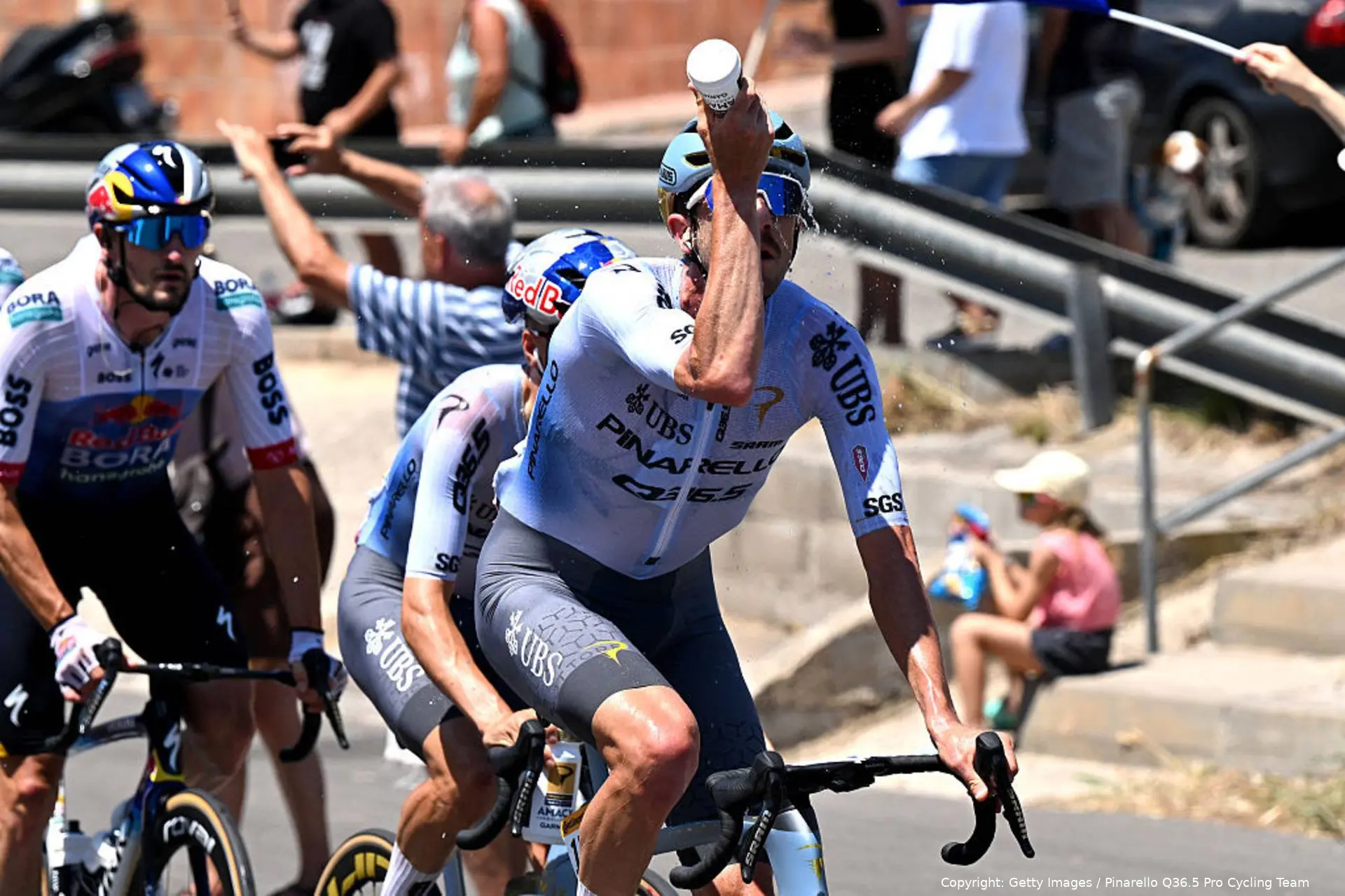 Pinarello Q36.5 rider sprays water on himself in an attempt to keep cool amid the searing Tour de France 2026 heatwave