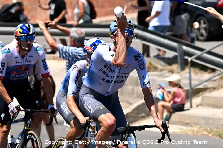 Pinarello Q36.5 rider sprays water on himself in an attempt to keep cool amid the searing Tour de France 2026 heatwave