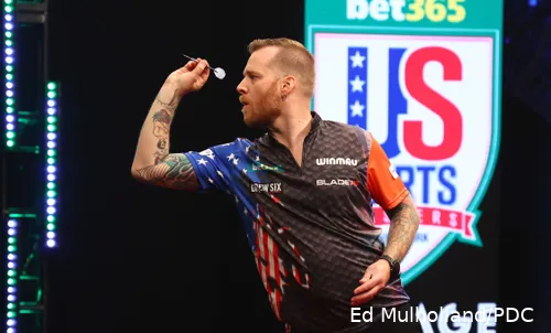 Jules van Dongen aims to throw his dart at the board.