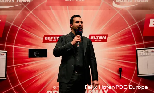 Philip Brzezinski met de microfoon in zijn handen op het podium.