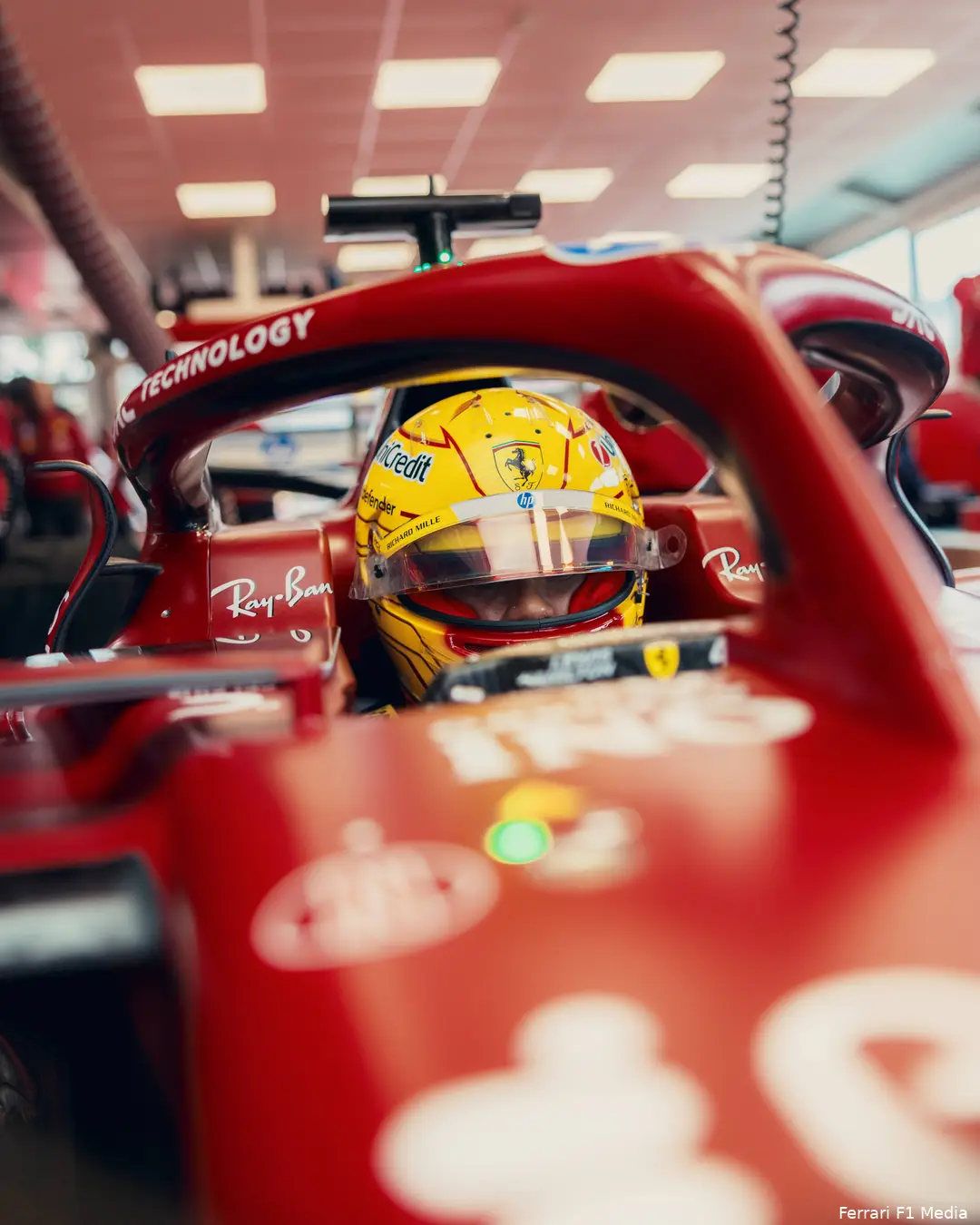 <i>Hamilton rijdt dit jaar met een gele helm in de rode Ferrari.</i>