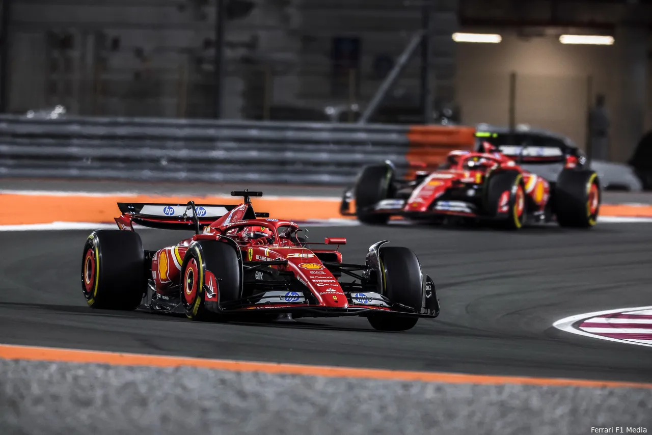 Charles Leclerc leads Carlos Sainz in Ferrari cars during the 2024 Qatar Grand Prix on a brightly lit night track.