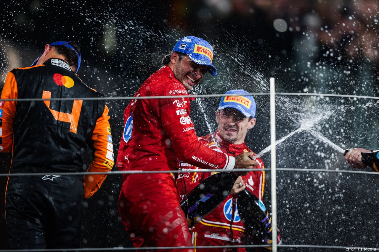 Lando Norris, Carlos Sainz, and Charles Leclerc spraying champagne in celebration on the podium after the 2024 Abu Dhabi Grand Prix.