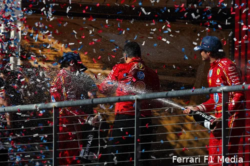Carlos Sainz sprays champagne on Charles Leclerc and race strategy head Ravin Jain during podium celebration at the 2024 United States Grand Prix.