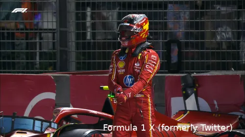 Carlos Sainz walking away from his crashed Ferrari in the background, heading towards the pit lane during the 2024 Singapore Grand Prix qualifying.
