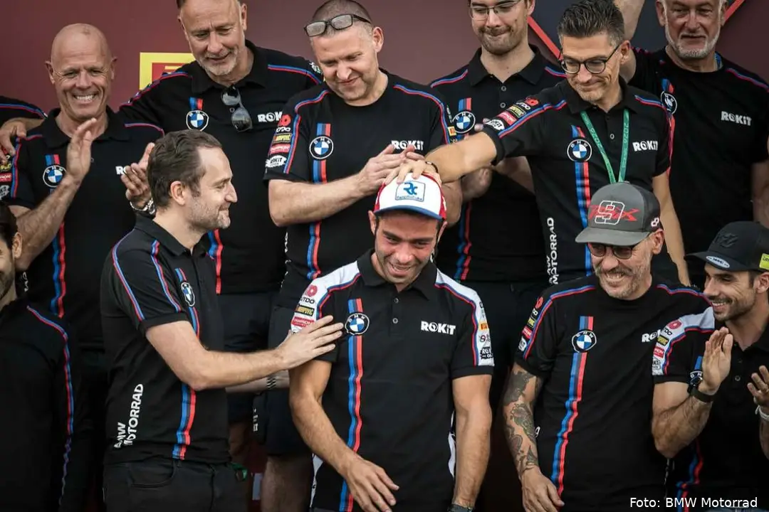Danilo Petrucci cries surrounded by the ROKiT BMW Motorrad WorldSBK team
