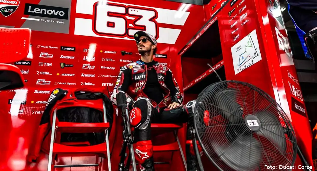 Pecco Bagnaia seduto nel box rosso del team Ducati MotoGP