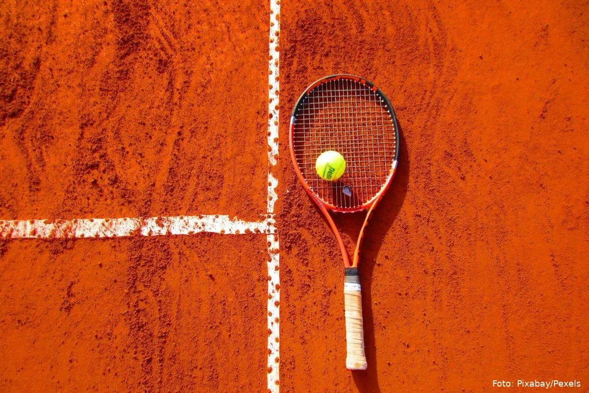 Tennisbold og -ketcher på clay court