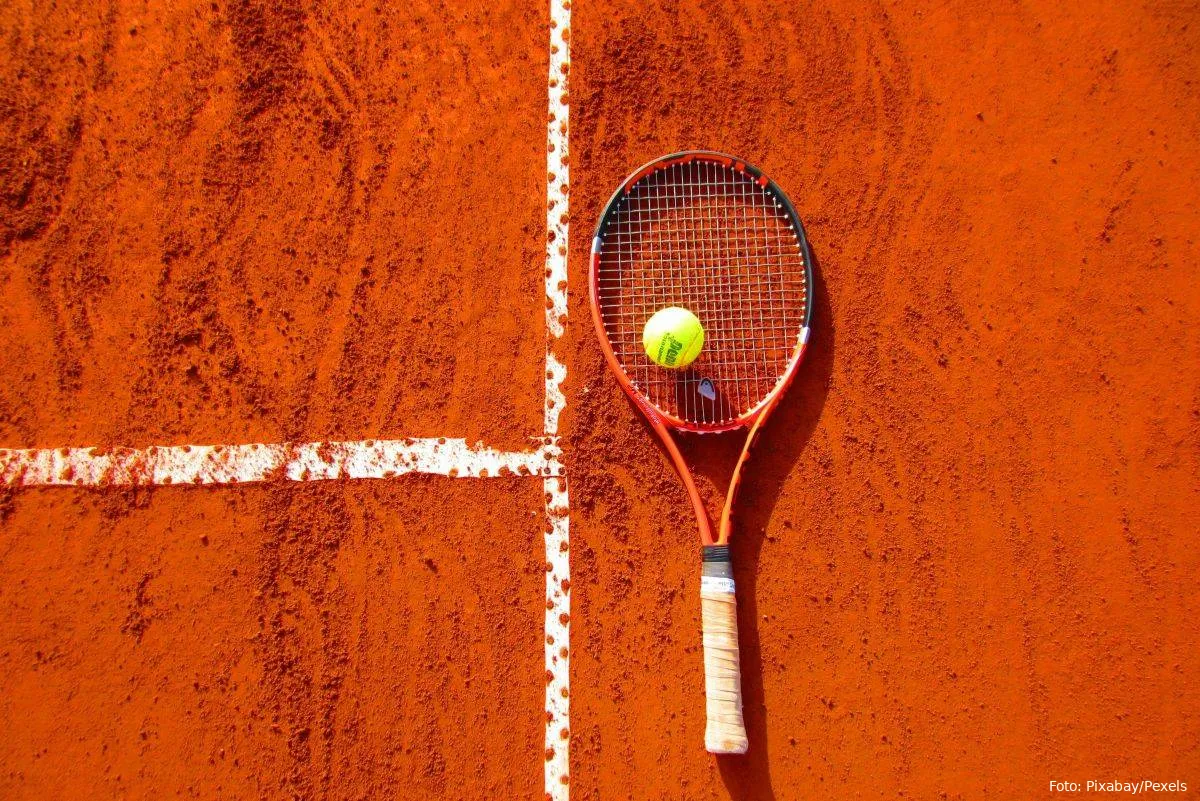 Tennisbold og -ketcher på clay court