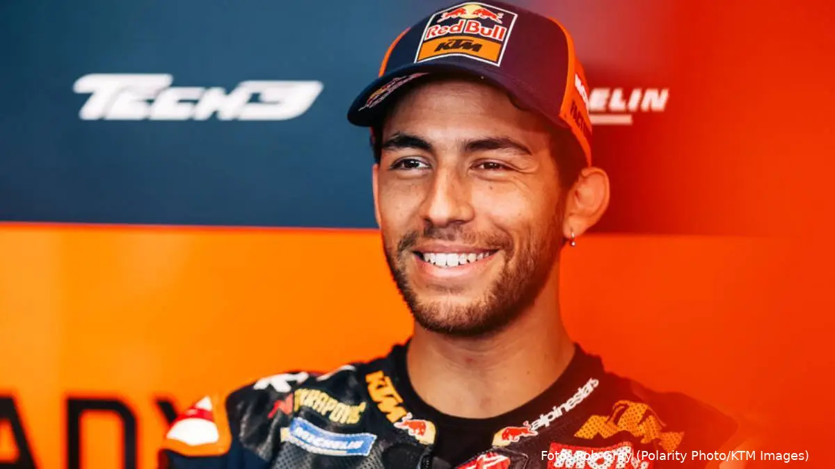 Enea Bastiani sorride mentre è seduto nel box del team KTM Tech3 MotoGP