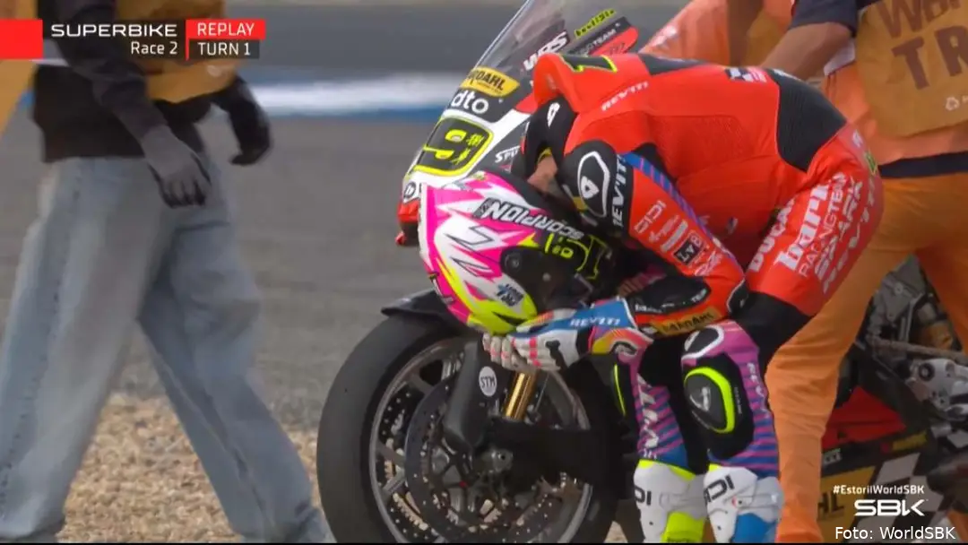 Alvaro Bautista crouched beside his Ducati Panigale V4 R SBK