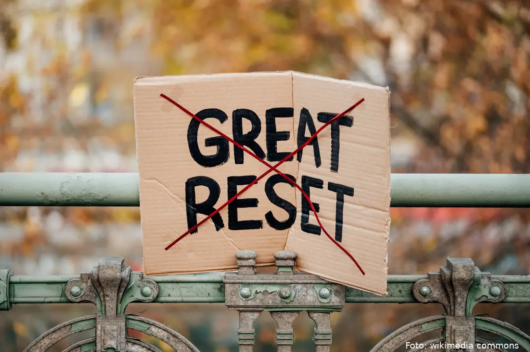 Sign_with_crossed_out_text__Great_Reset__left_stuck_to_a_railing_in_Vienna,_Austria_(51693638346)
