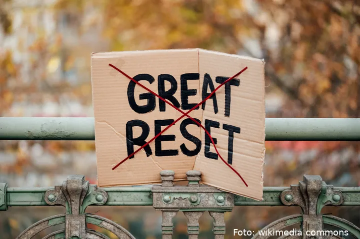 Sign_with_crossed_out_text__Great_Reset__left_stuck_to_a_railing_in_Vienna,_Austria_(51693638346)