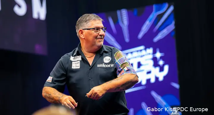 Gary Anderson looks on.