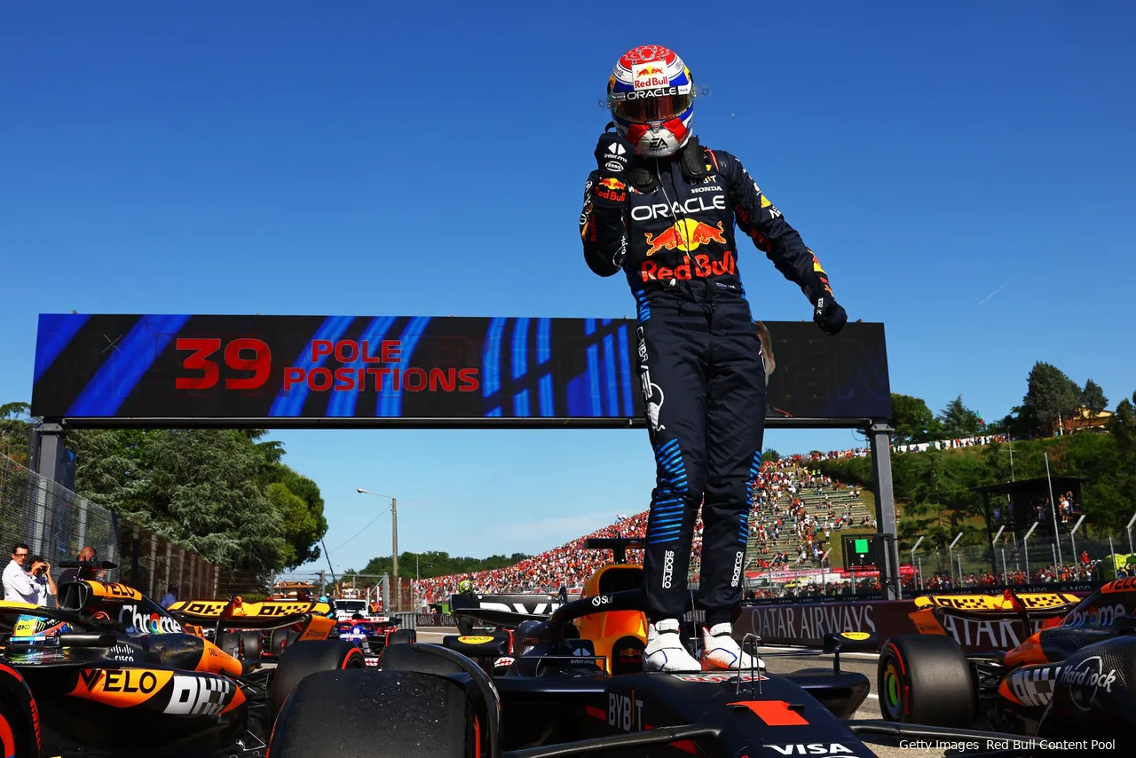 Max Verstappen standing on top of his car and celebrating after the 2024 Emilia Romagna Grand Prix victory.