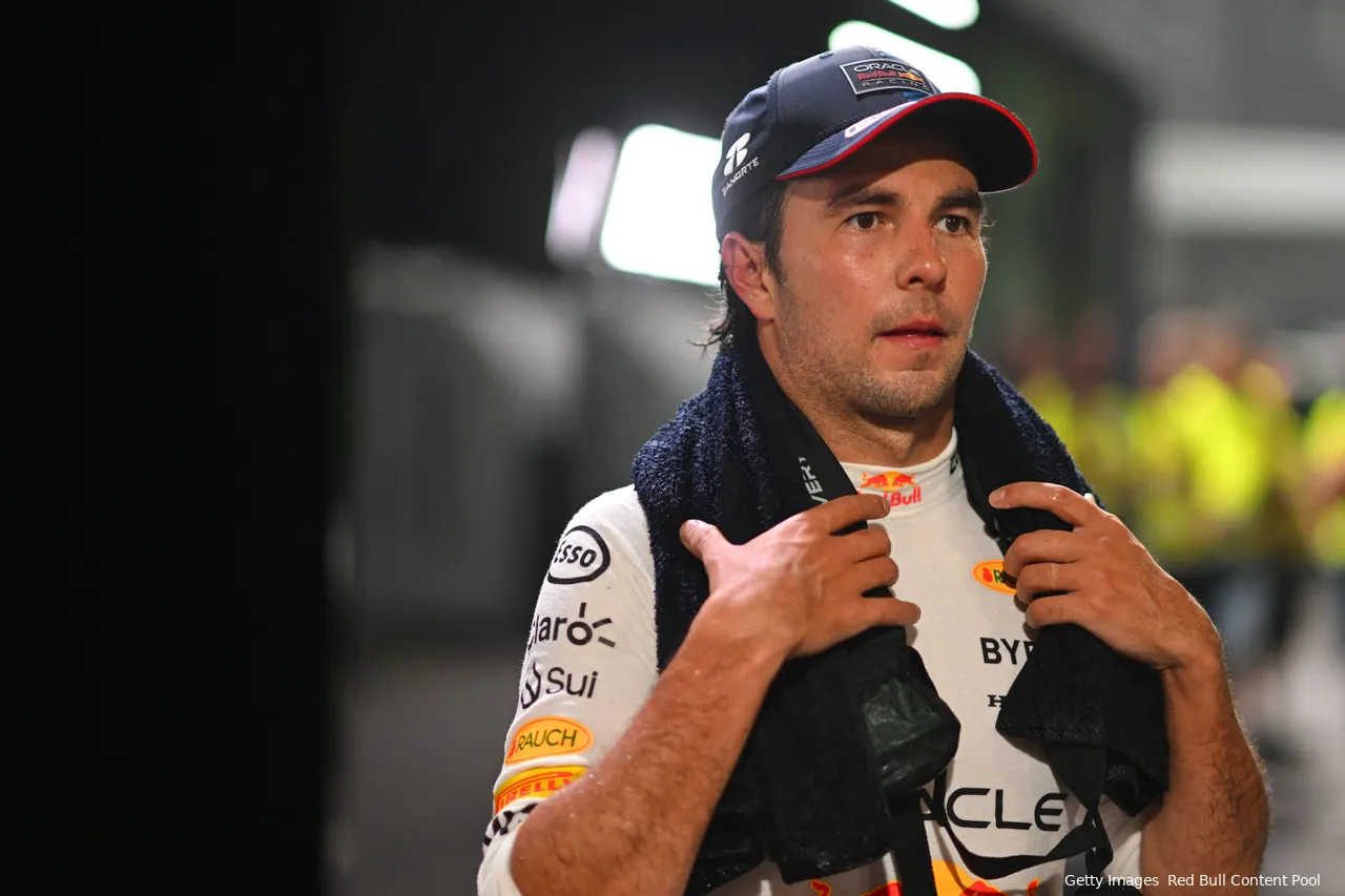 Tired and sweaty Sergio Perez in his driver uniform, with a towel around his neck, walking through the paddock after finishing P10 at the 2024 Singapore Grand Prix.