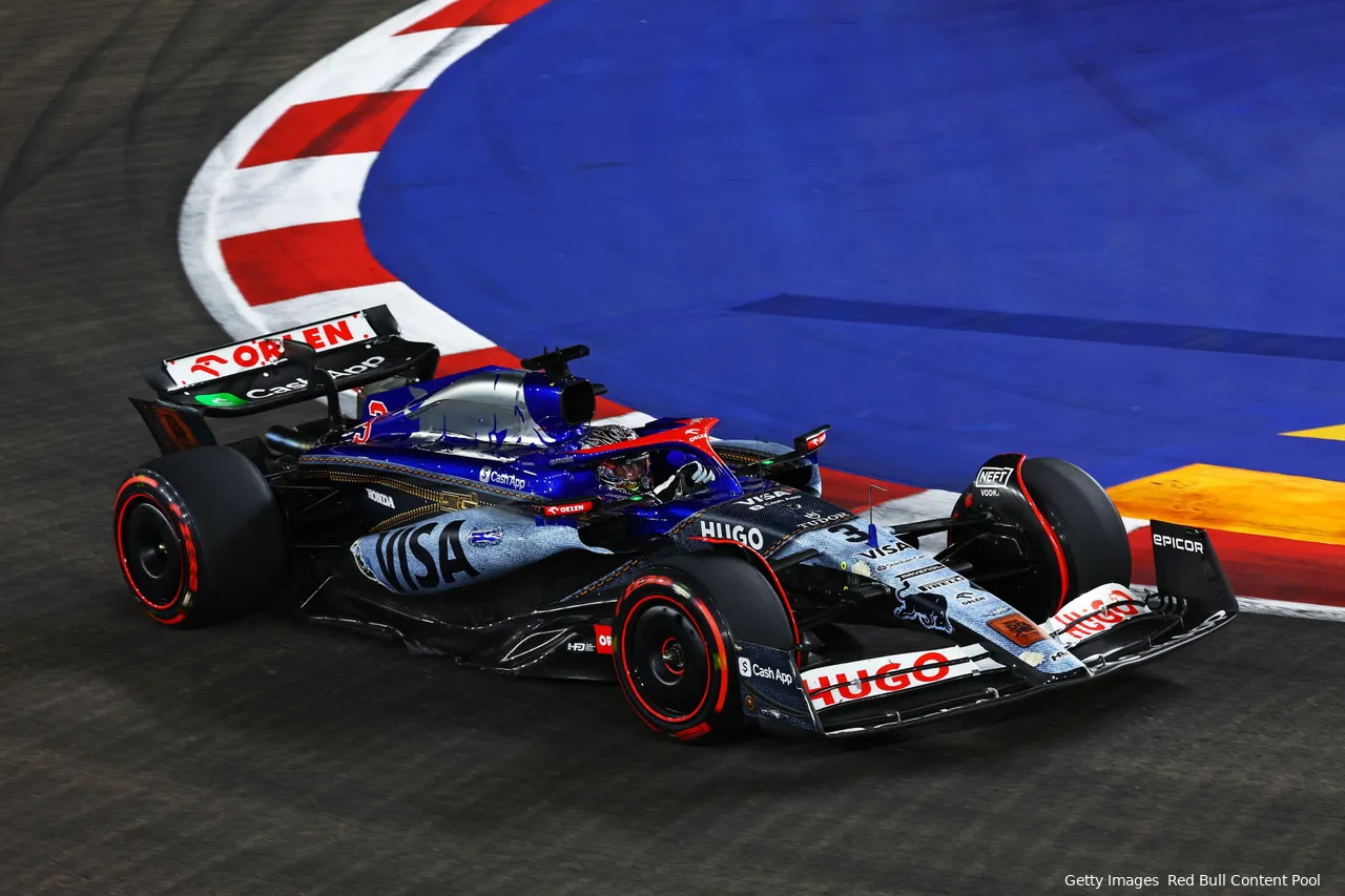 Daniel Ricciardo in his special livery F1 car with soft tires riding the curb on a flying lap at the 2024 Singapore Grand Prix.
