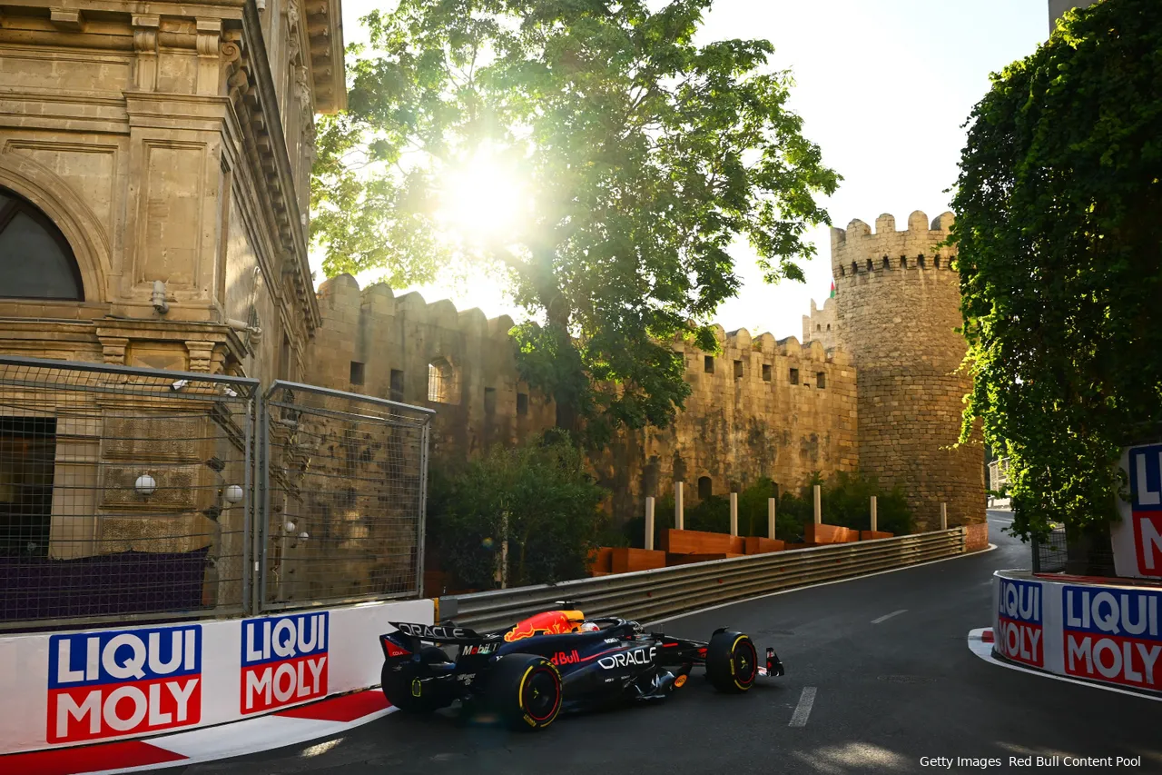 Max Verstappen, in his RB20, enters the narrow 'Castle section' at turn eight of the Baku City Circuit, with fortress walls in the background.