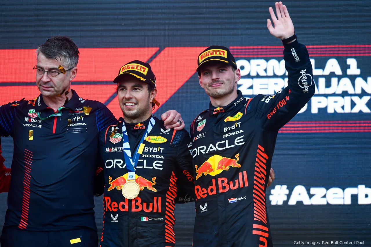 Max Verstappen with Sergio Perez and Red Bull's Head of Electronics Paul Everington, standing next to each other on the podium after the 2023 Azerbaijan Grand Prix.