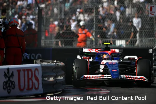 Yuki Tsunoda driving his VCARB extremely close to the turn 15 barrier during the 2024 Monaco Grand Prix, with fans and marshals visible behind the fence in the background.