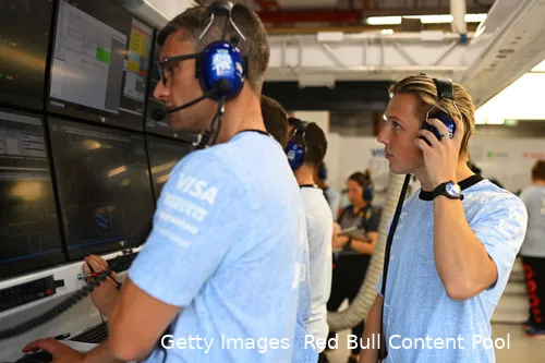 Liam Lawson in Daniel Ricciardo's garage viewing data screens during the free practice session before the 2024 Singapore Grand Prix.