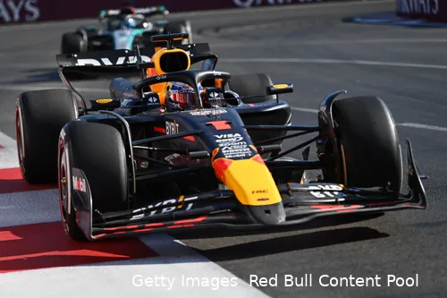 Max Verstappen exiting a corner, closely followed by George Russell's Mercedes in the background during the 2024 Azerbaijan Grand Prix.