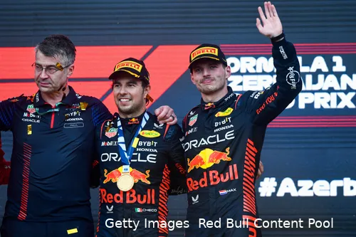 Max Verstappen with Sergio Perez and Red Bull's Head of Electronics Paul Everington, standing next to each other on the podium after the 2023 Azerbaijan Grand Prix.
