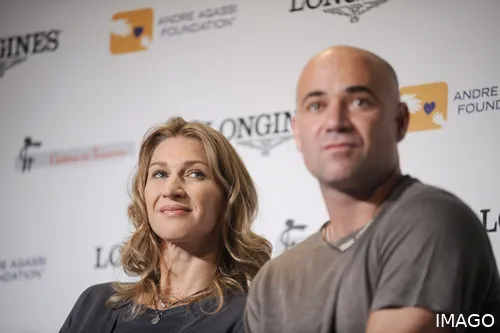 Steffi Graf and Andre Agassi sat at press conference looking at journalist.