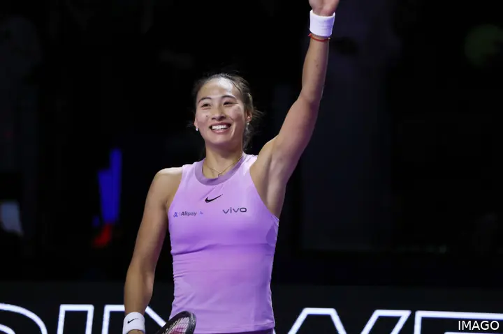 Zheng Qinwen raises her arm.